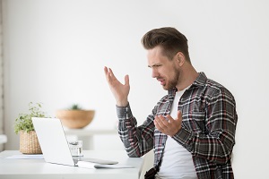 Frustrated young man looking at email